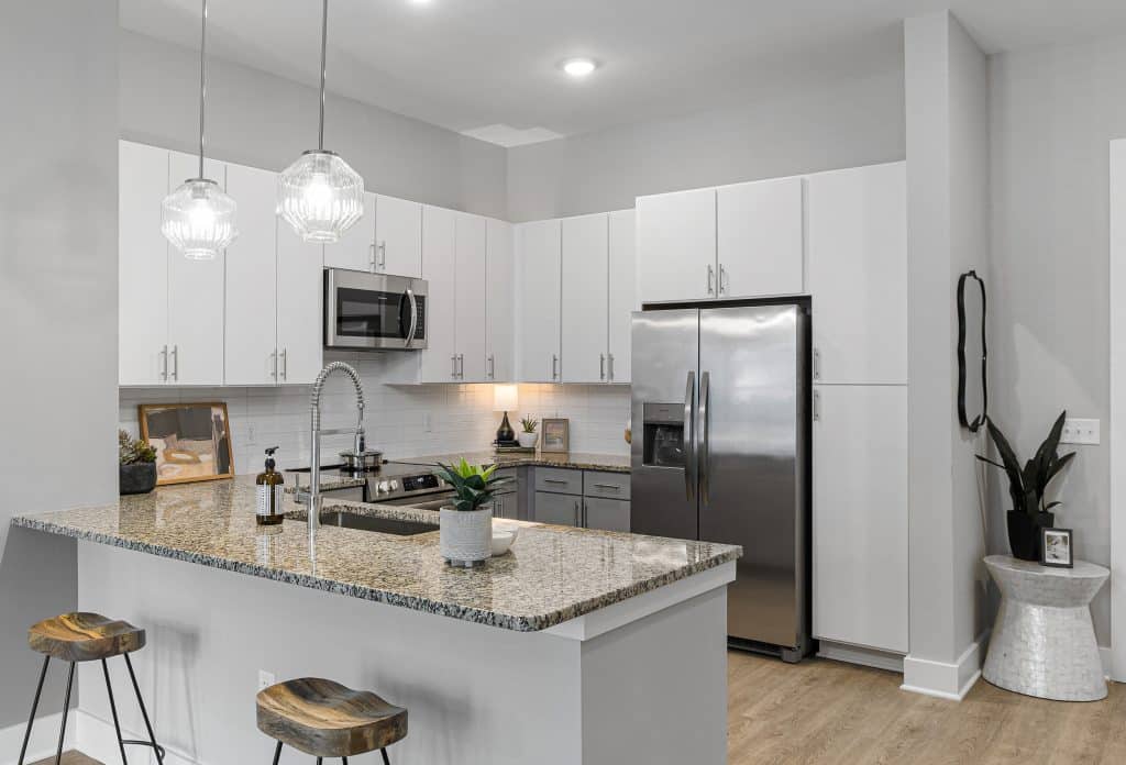 Kitchen bar and stainless steel appliances in apartment homes at The Ames